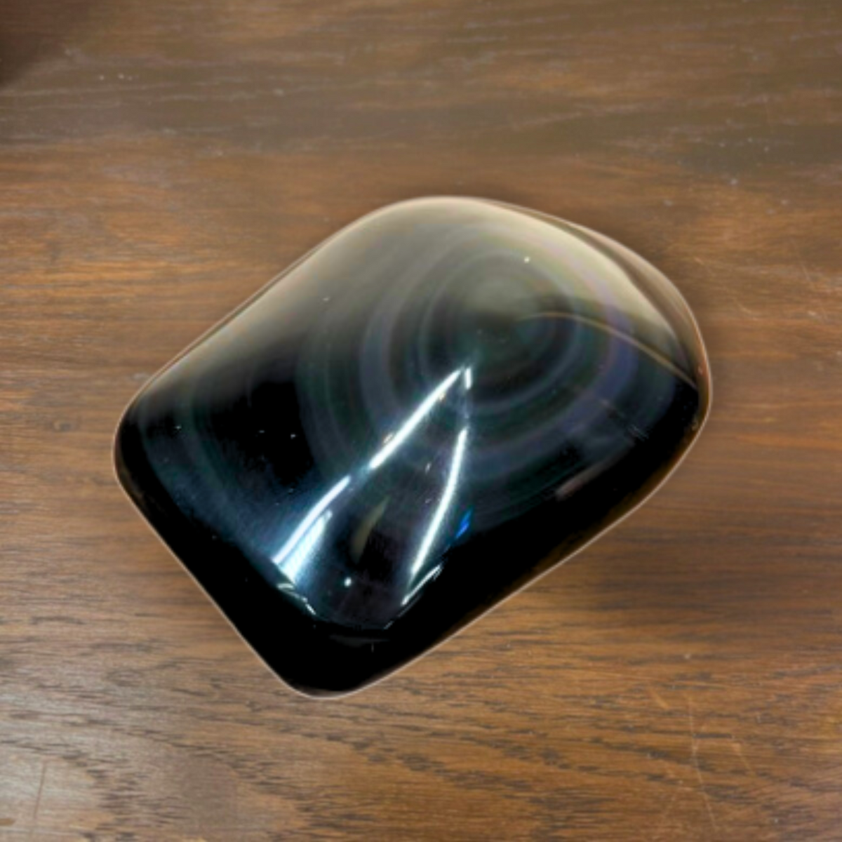 Black oval object on a wooden surface