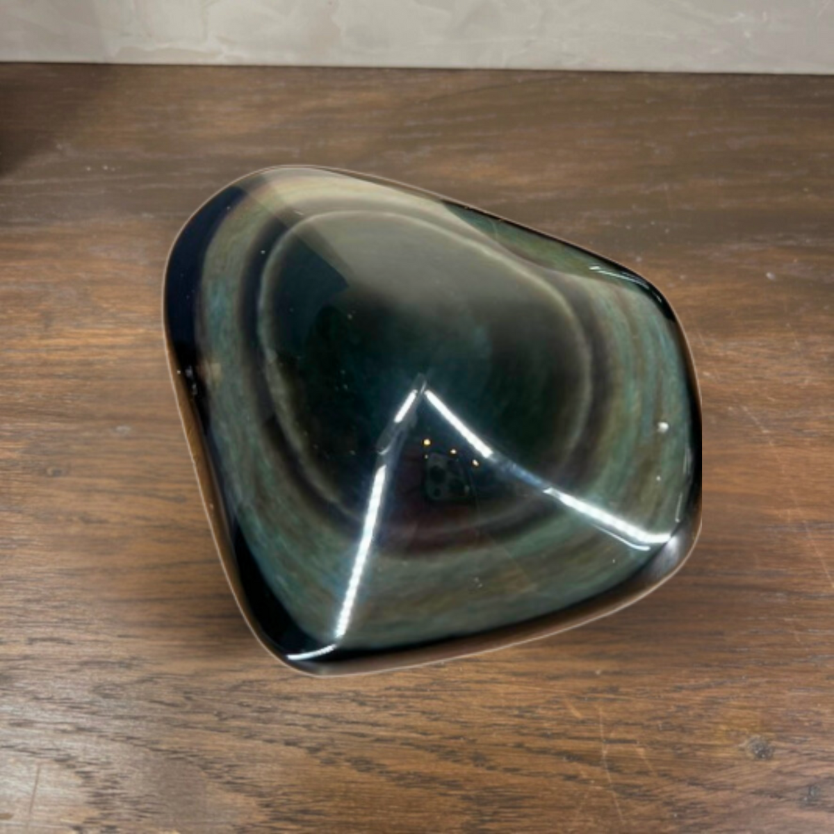 Metallic, faceted object on a wooden surface