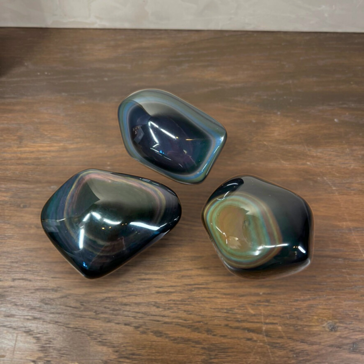Three polished stones on a wooden surface