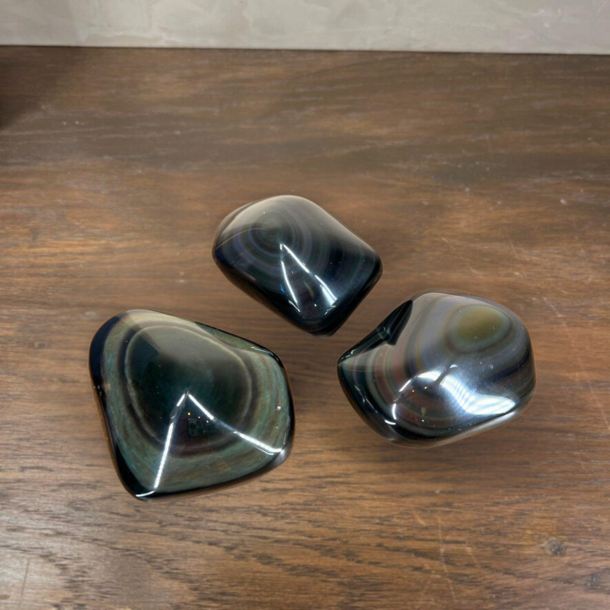 Three polished agate stones on a wooden surface