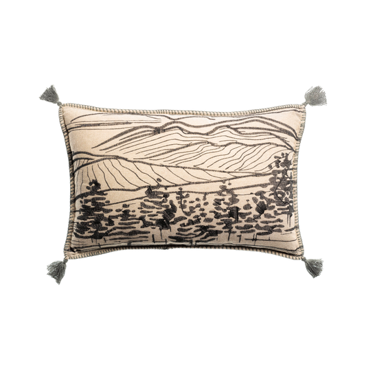 Decorative pillow with landscape design and tassels on a white background