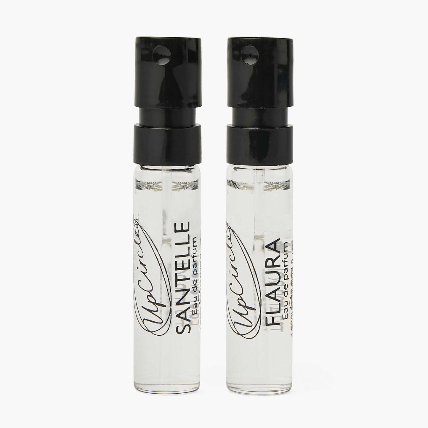 Two clear perfume bottles with black caps on a white background