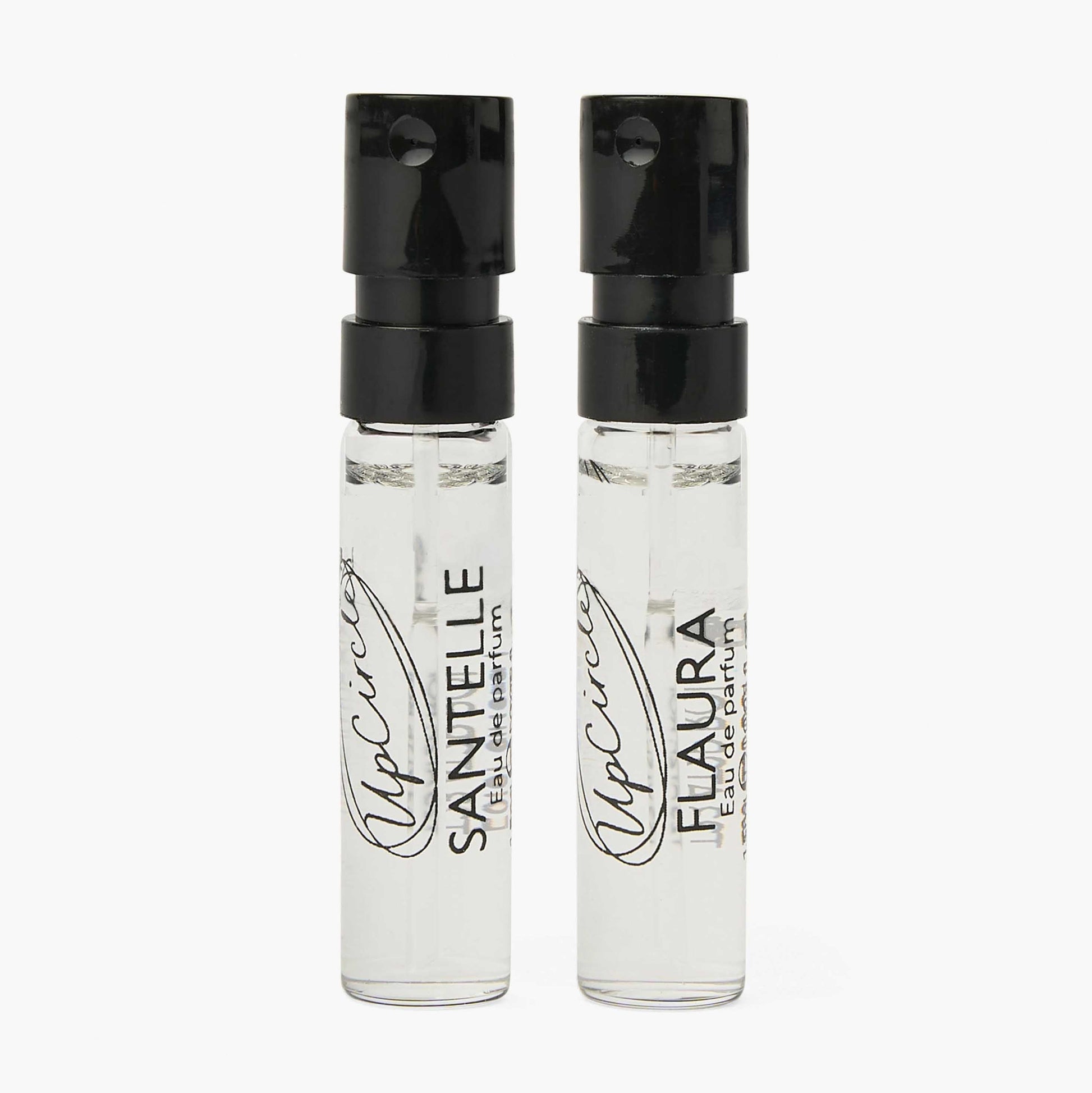 Two clear perfume bottles with black caps on a white background