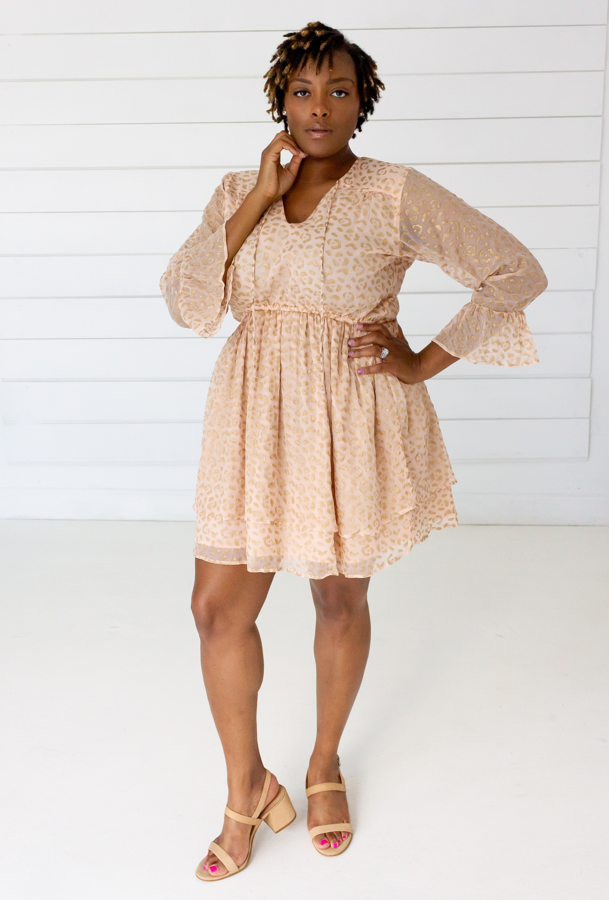 Woman wearing a beige lace dress against a white background