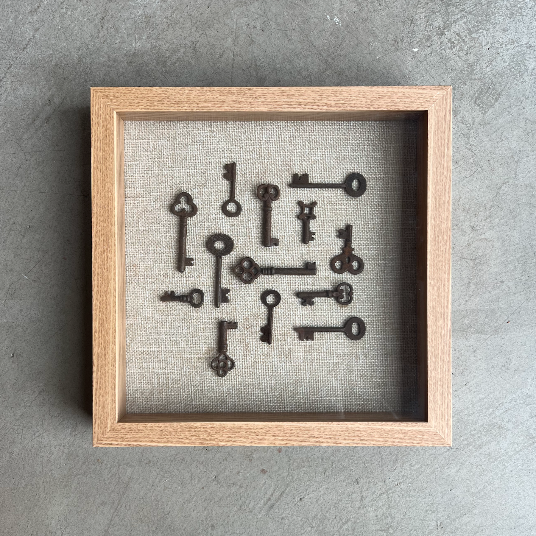Framed collection of vintage keys on a textured gray background