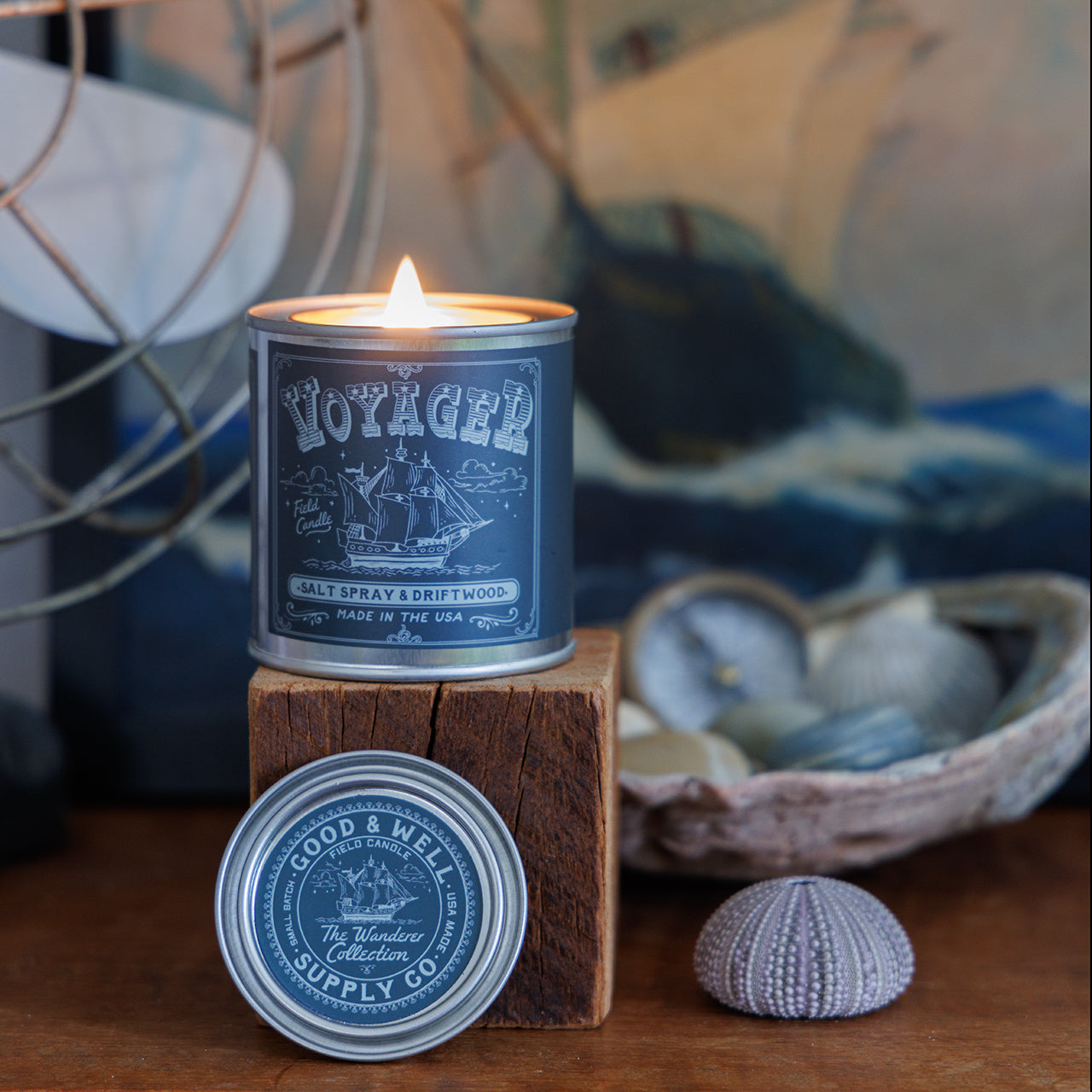 Voyager candle in a decorative setting with a ship illustration on the label.