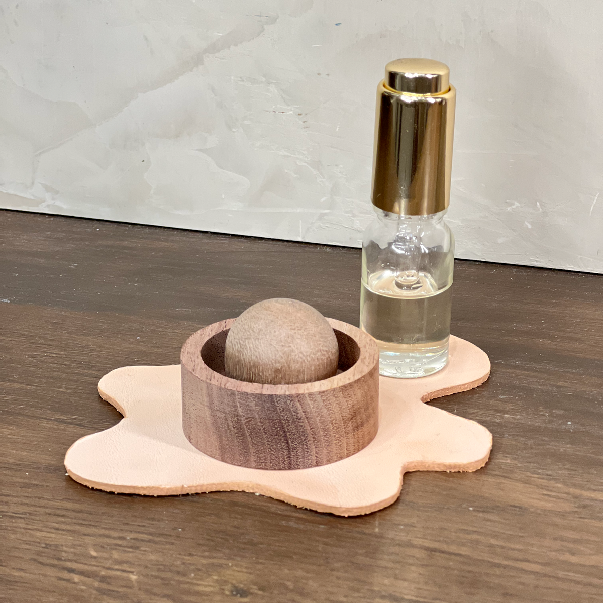 Wooden bowl with a stone and a glass bottle on a wooden surface