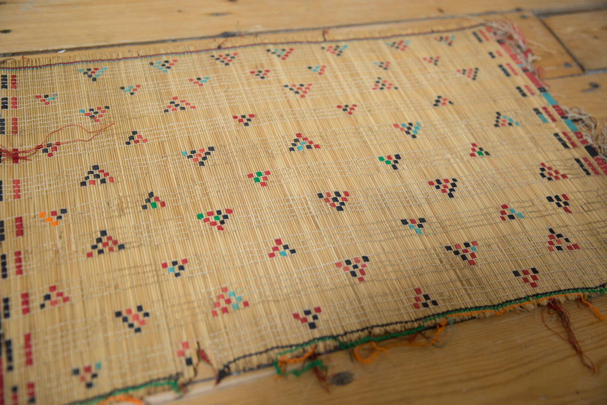 Woven fabric with colorful geometric patterns on a wooden surface