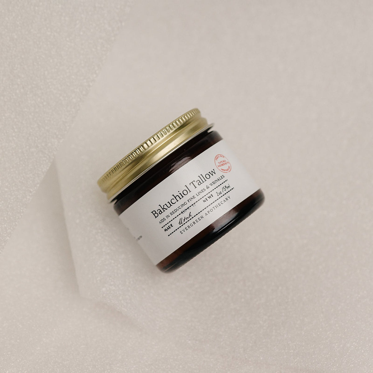 Jar of Bakuchiol Tallow on a beige background