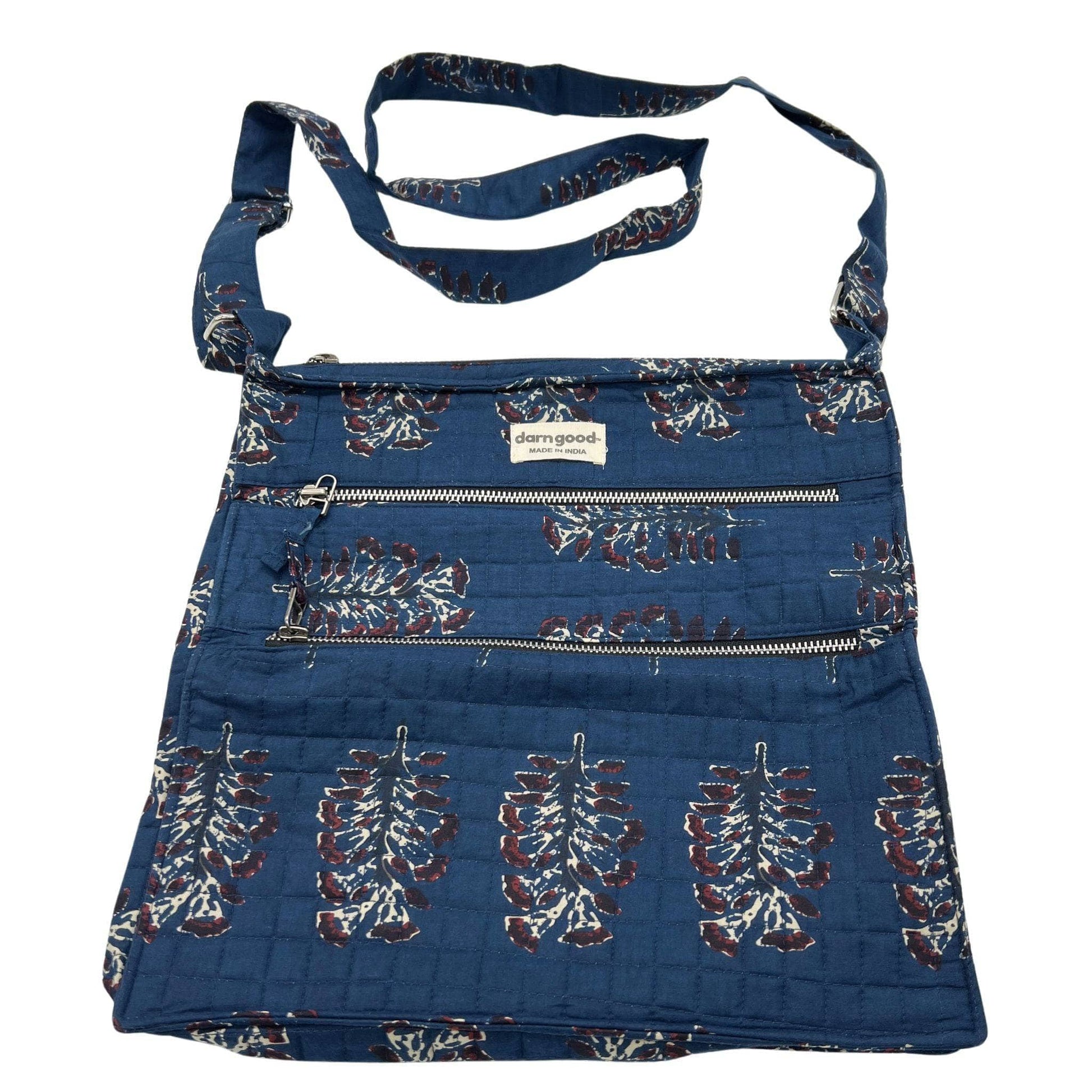 Blue denim bag with floral patterns and a strap on a white background