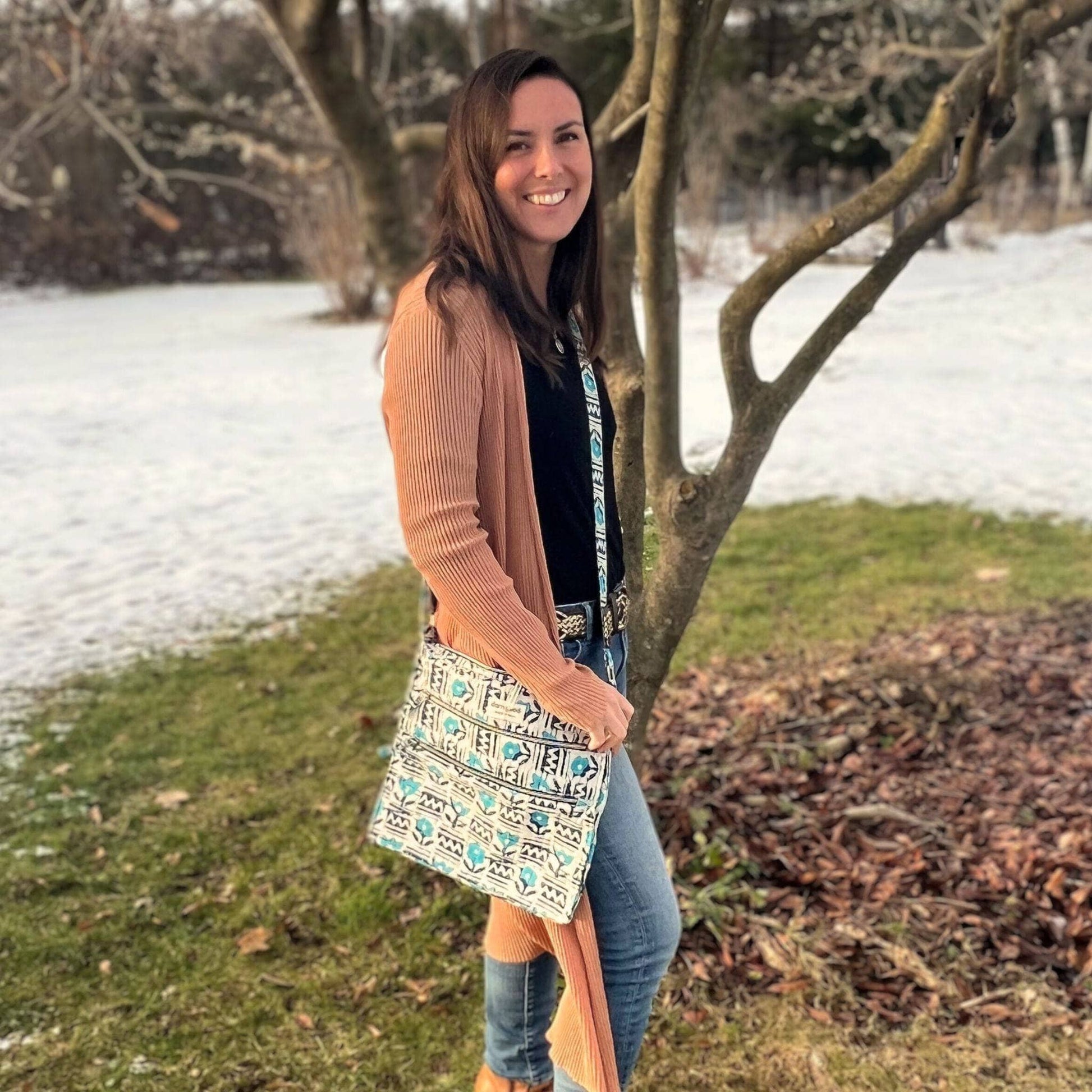 Woman holding a patterned bag in a snowy landscape