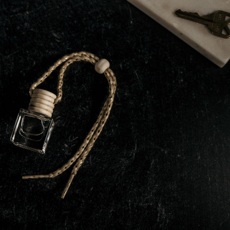 Small glass bottle with a string on a dark textured surface