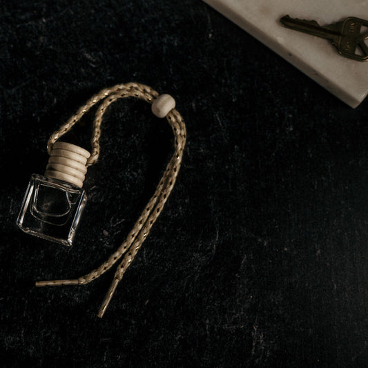 Small glass bottle with a string on a dark textured surface
