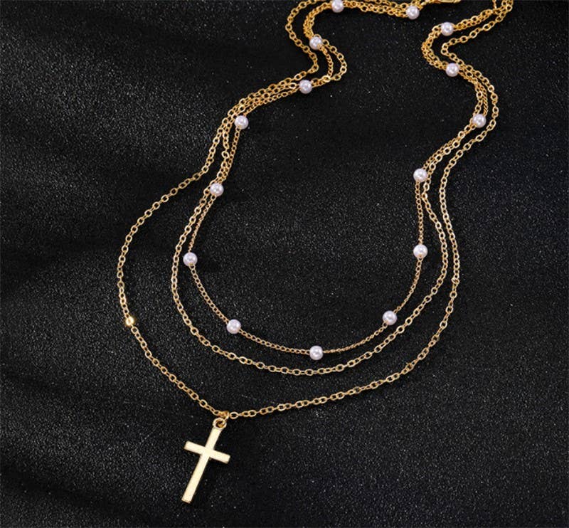 Gold necklace with cross pendant on a black background