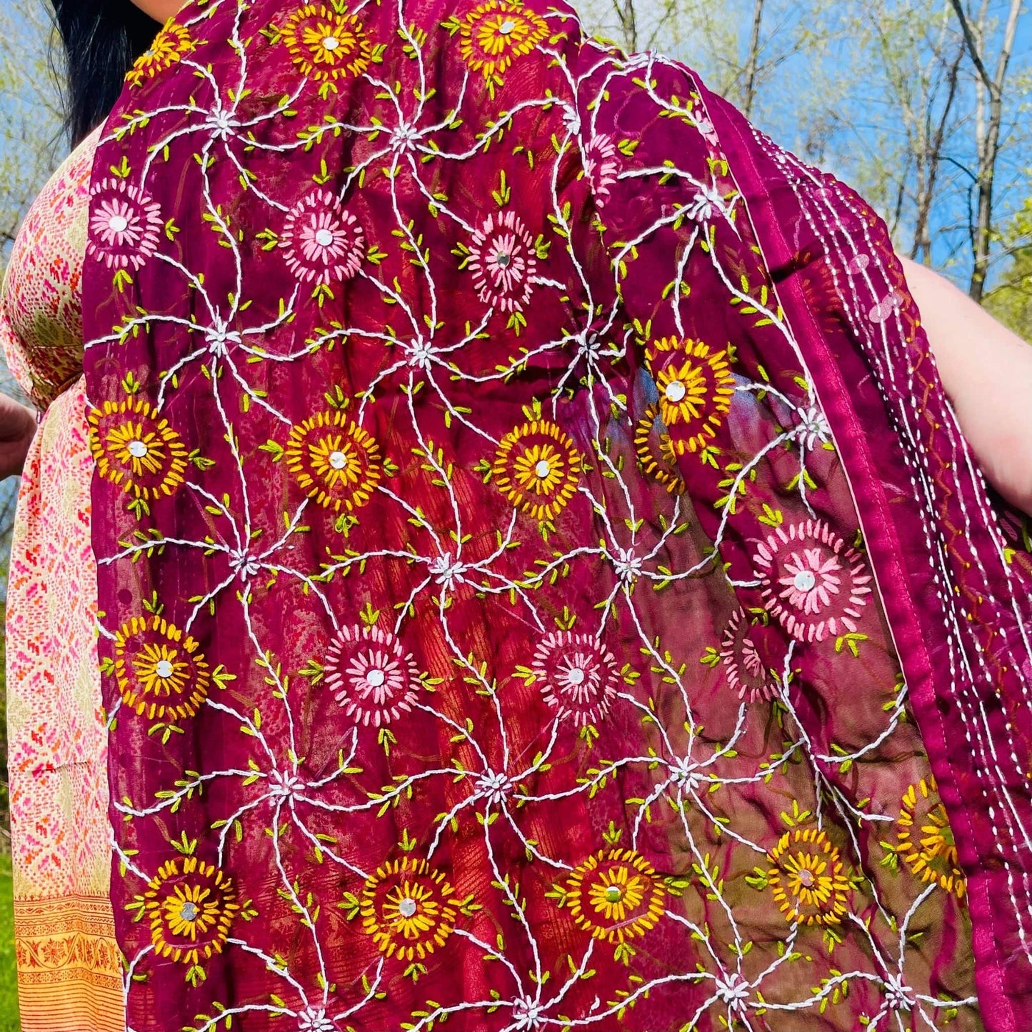 Close-up of a vibrant floral-patterned fabric with a blurred natural background