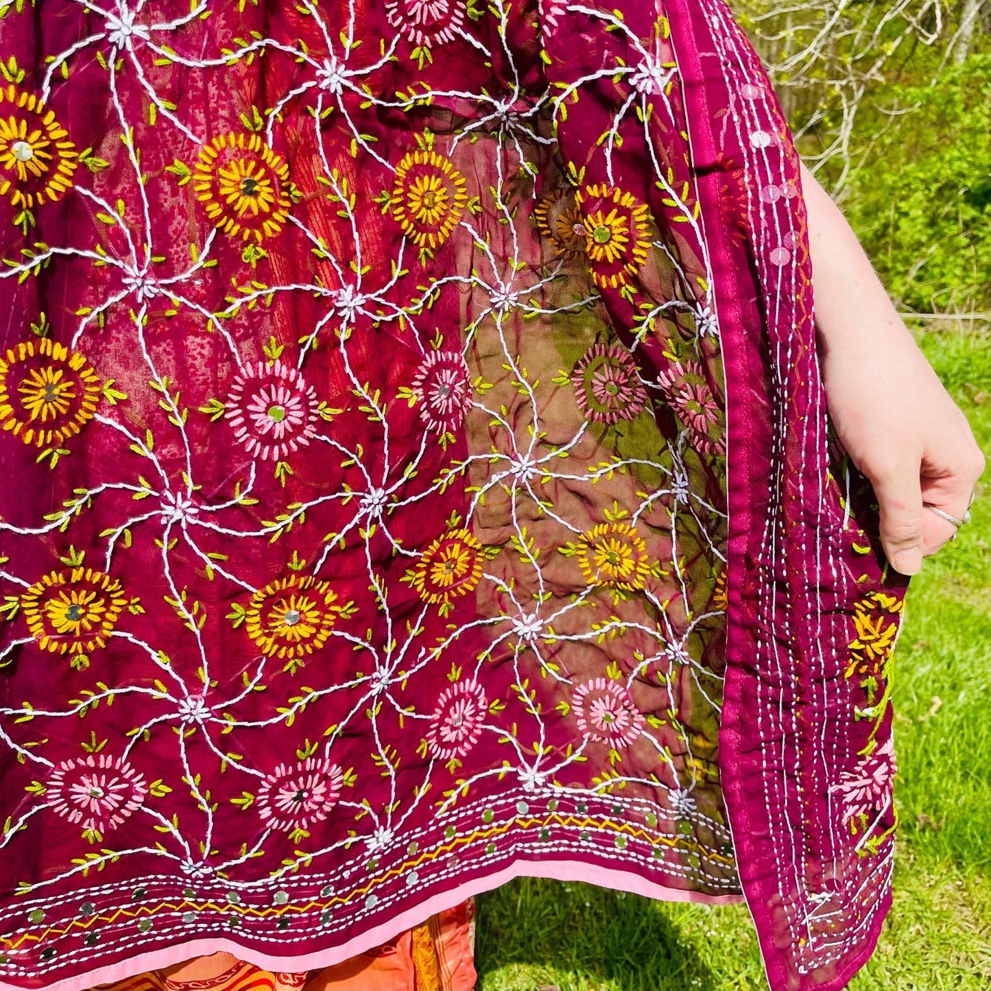 Close-up of a vibrant floral-patterned fabric with a blurred natural background