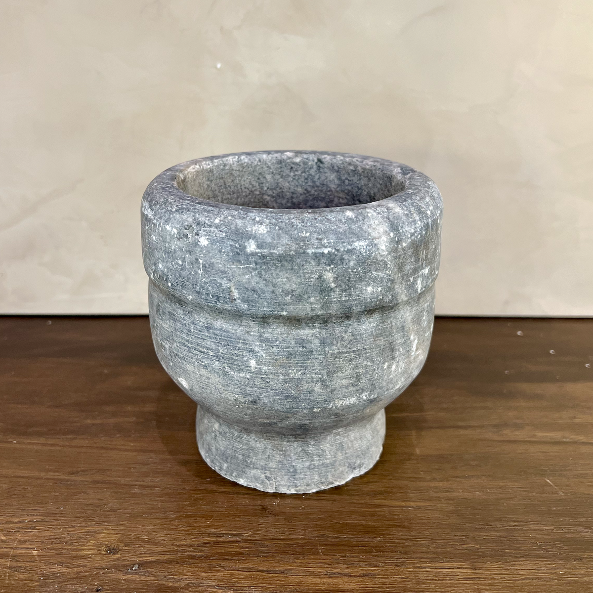 Stone mortar on a wooden surface with a neutral background