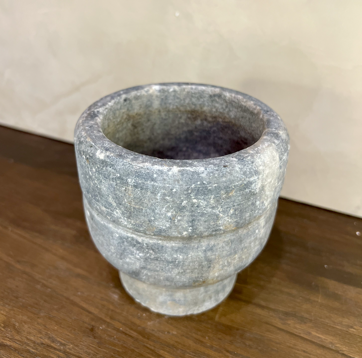 Stone mortar on a wooden surface with a neutral background