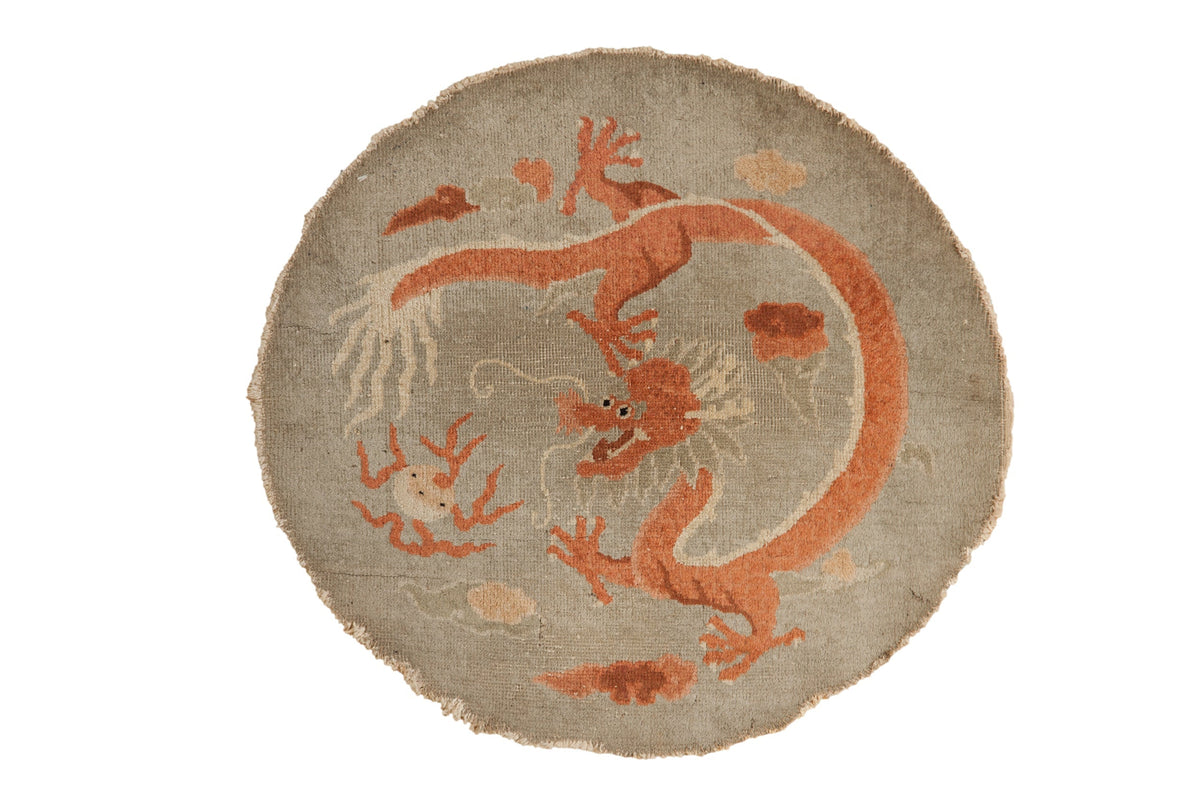 Round rug with red dragon design on a beige background