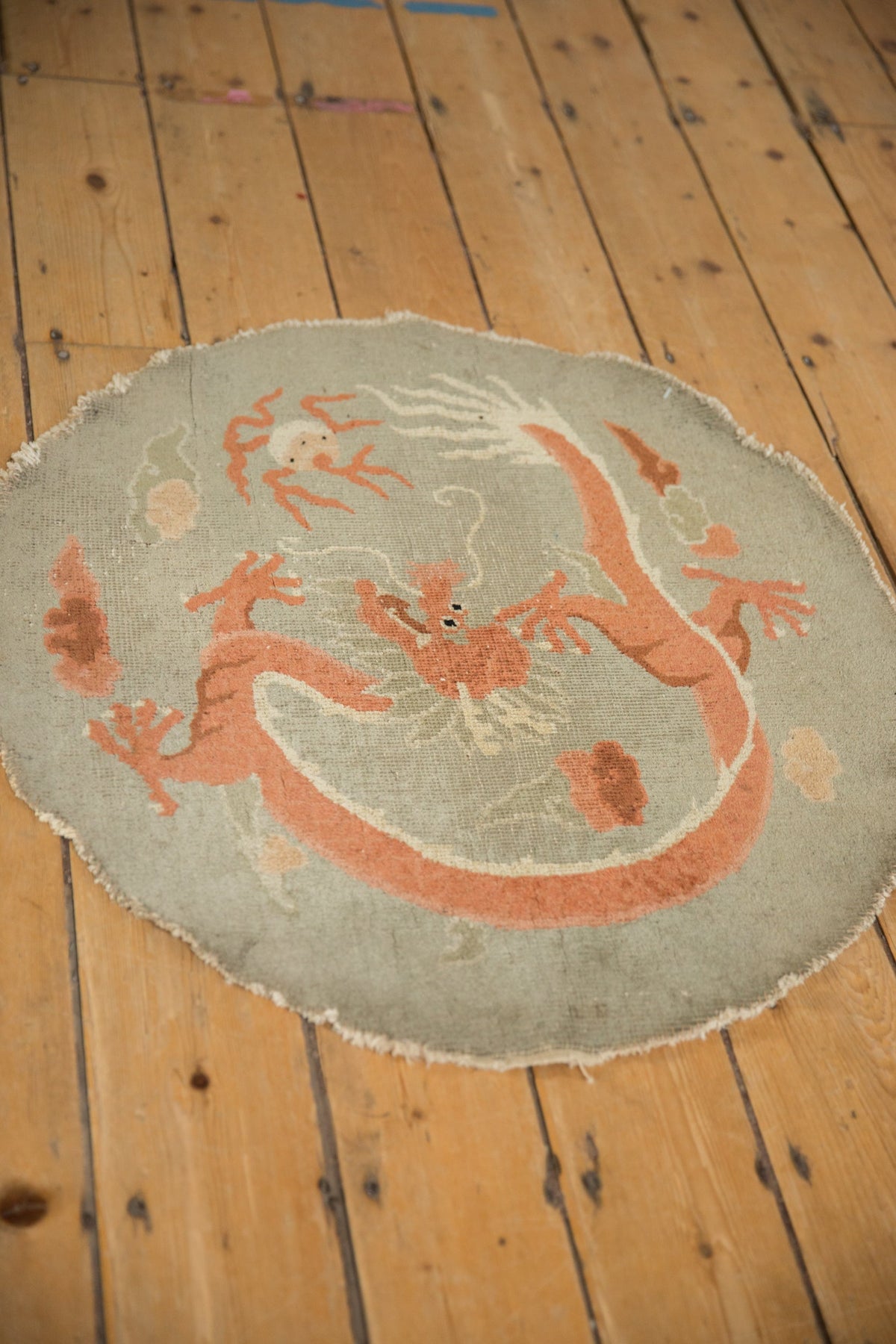 Round rug with a dragon design on a wooden floor