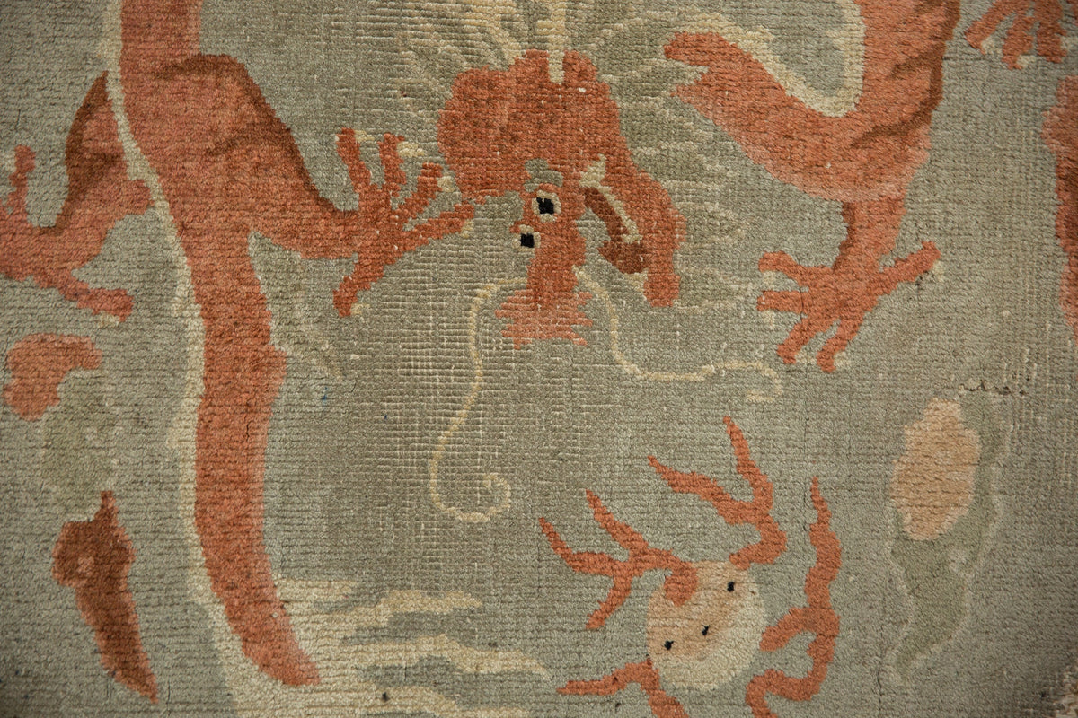 Close-up of a textured fabric with red and beige patterns on a gray background.