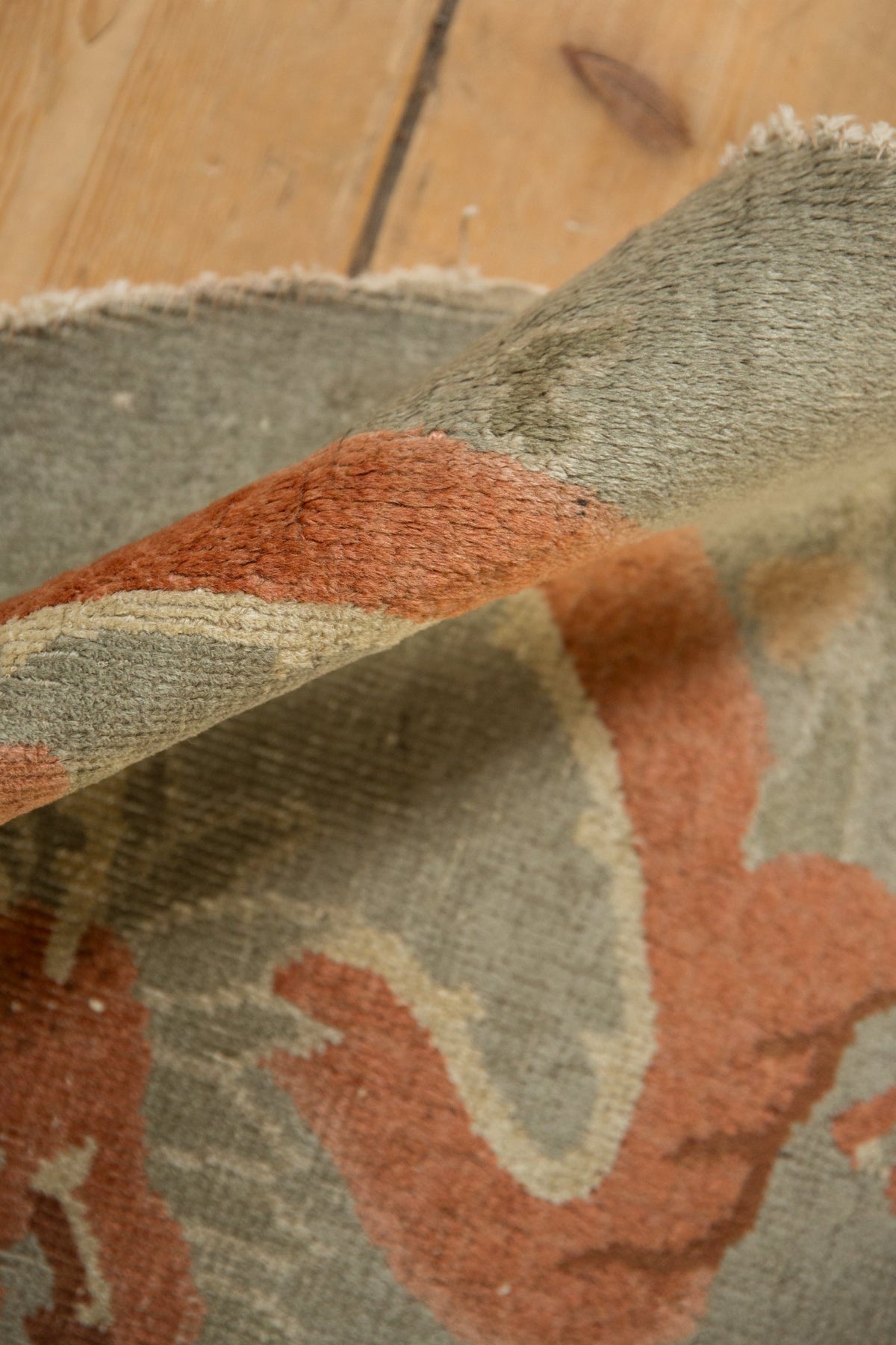 Close-up of a textured rug with geometric pattern on wooden floor