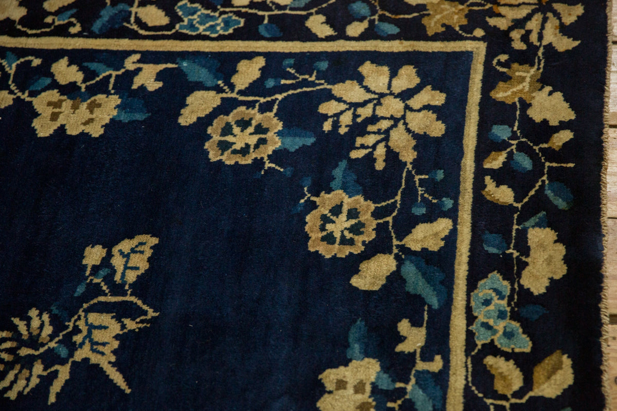 Close-up of a floral-patterned rug with blue and gold colors.