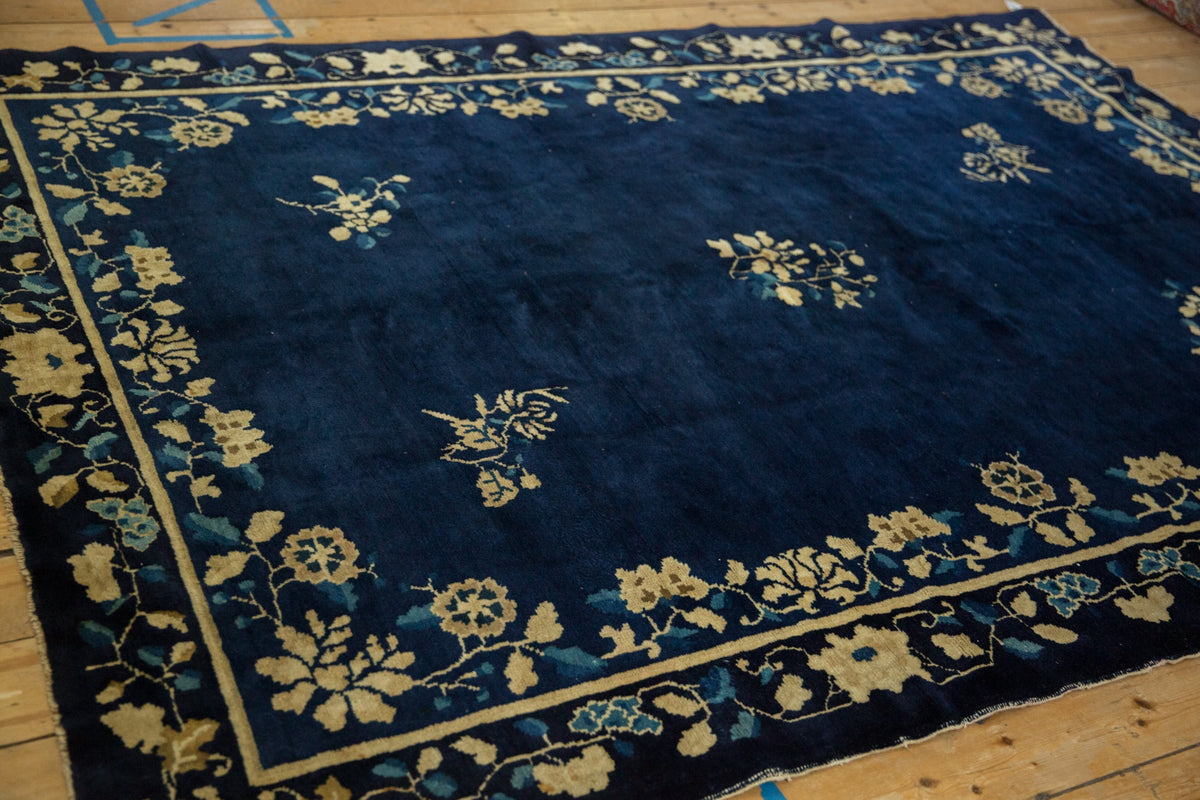 Blue rug with white floral patterns on a wooden floor