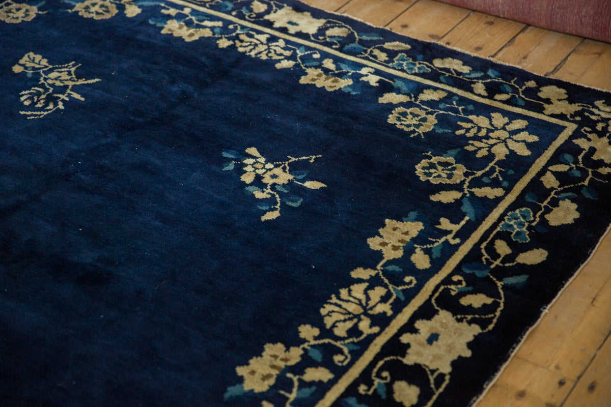 Navy blue rug with floral patterns on a wooden floor