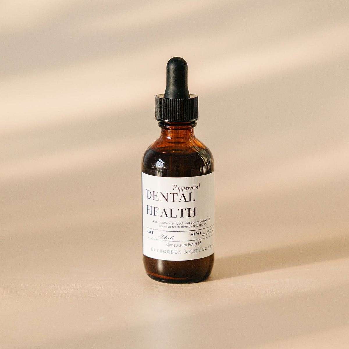 Bottle of dental health serum with dropper on a beige background
