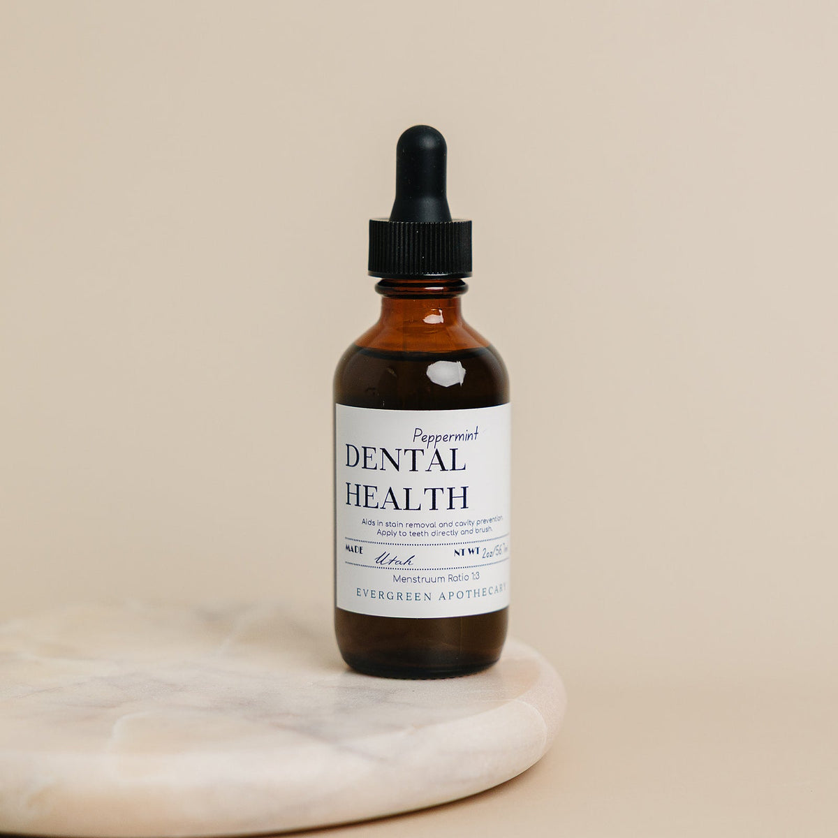 Bottle of dental health product with dropper on a beige background