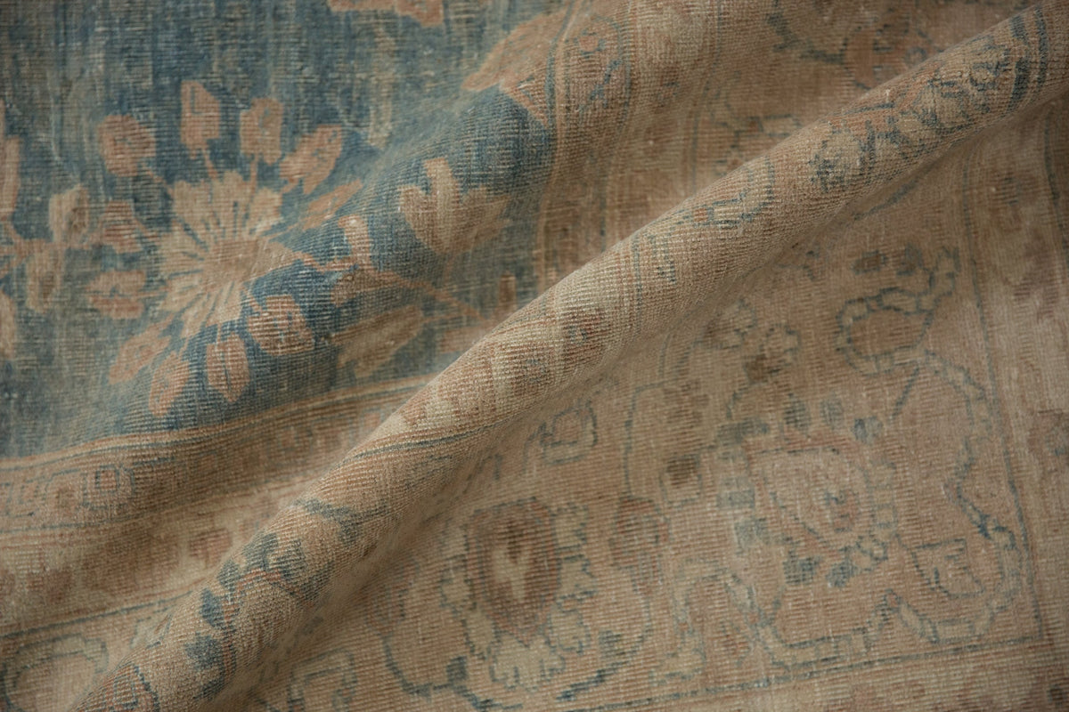 Close-up of a textured fabric with floral patterns in brown and blue tones.