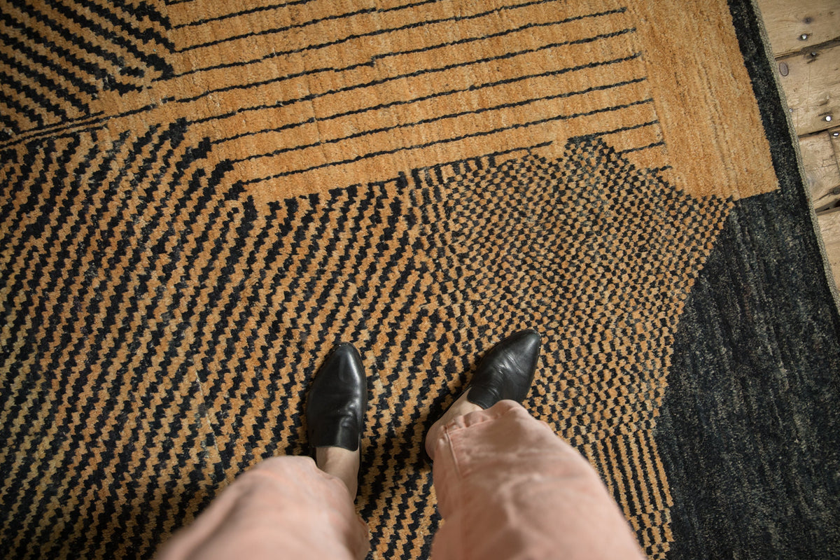 Person wearing black shoes stepping onto a textured rug.