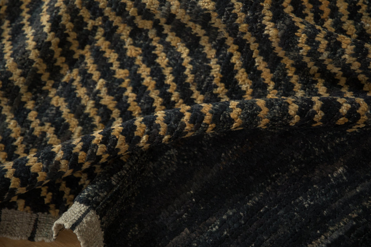 Close-up of a textured fabric with a herringbone pattern in black and beige.
