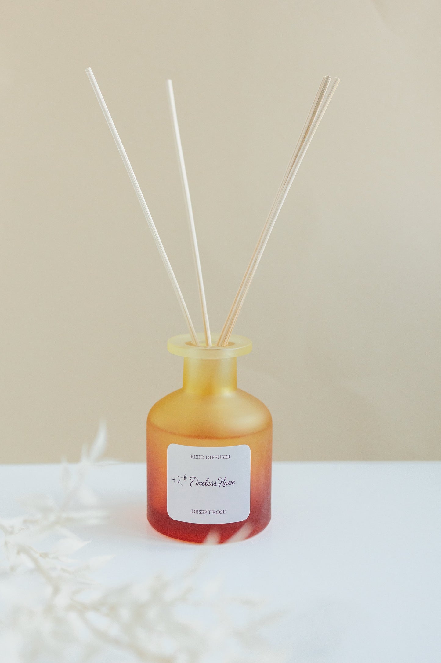 Reed diffuser with a gradient bottle design on a neutral background