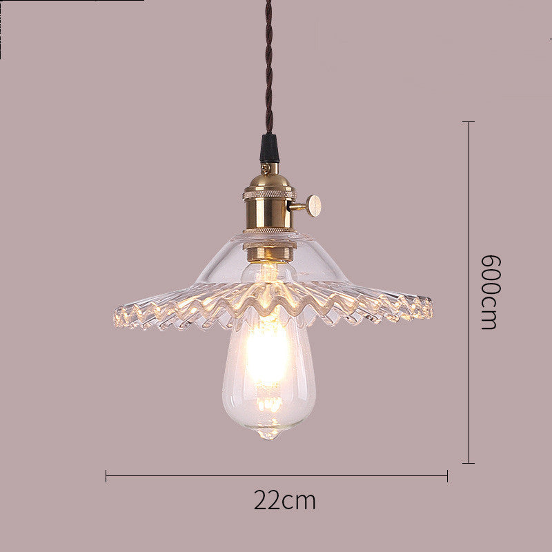 Vintage-style pendant light with clear glass shade and gold fixture, on a plain background.