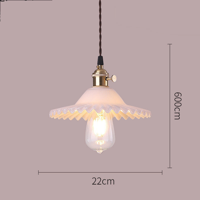 Vintage-style pendant light with decorative glass shade and measurement details on a plain background