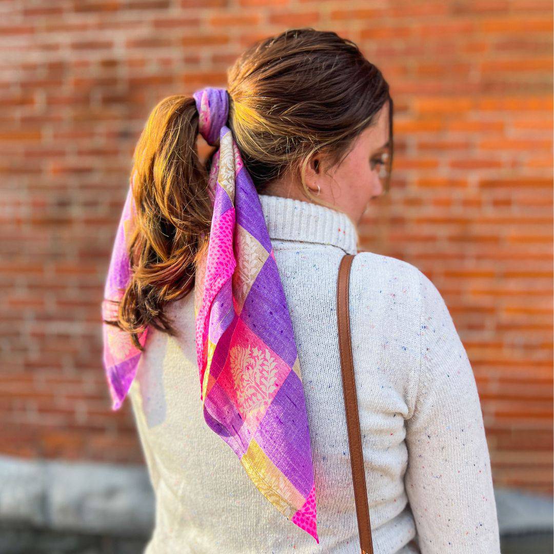 Woman wearing a colorful scarf with a brick wall background