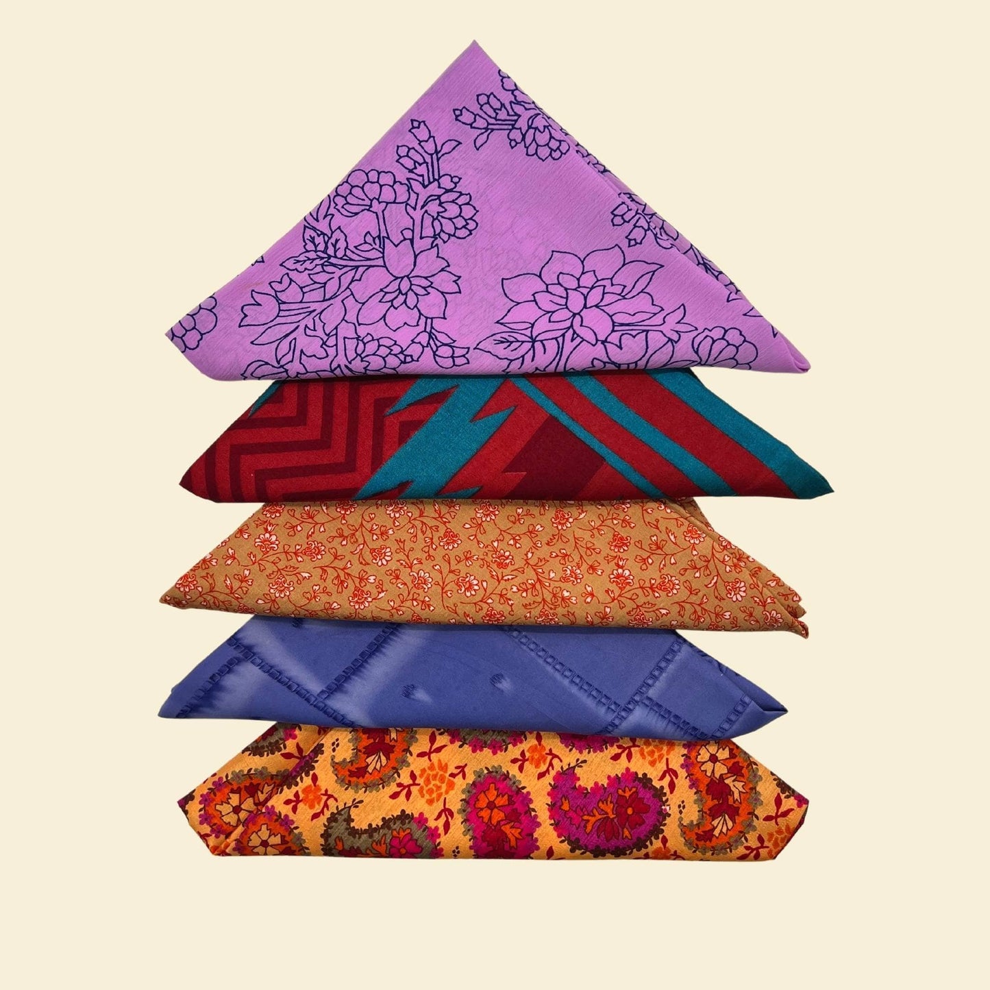 Stack of colorful folded fabric pieces on a beige background