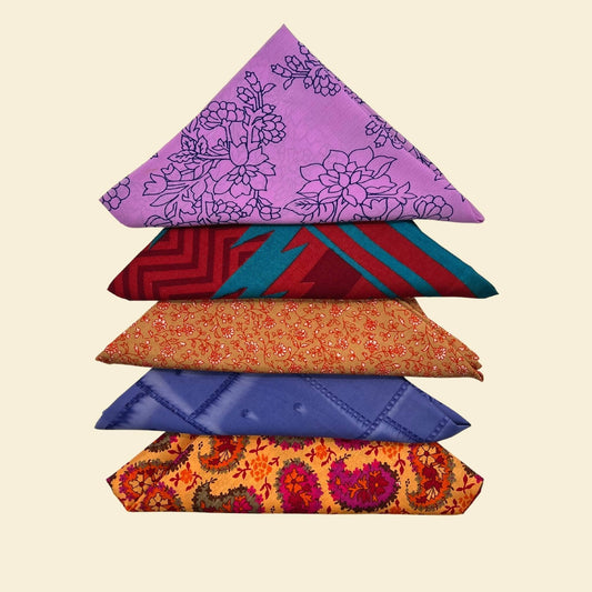 Stack of colorful folded fabric pieces on a beige background