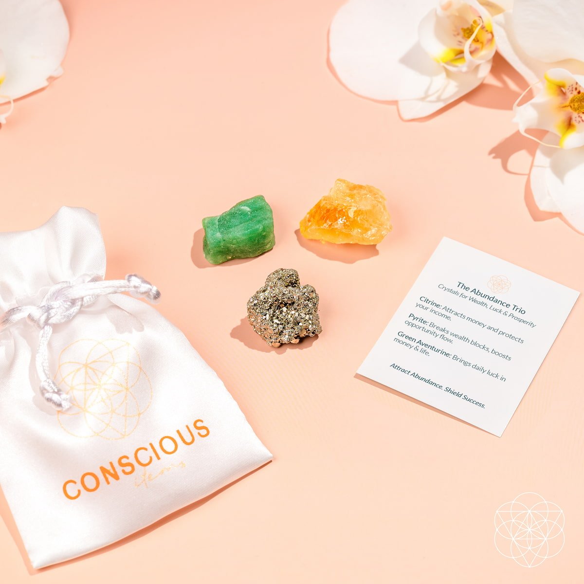 Three crystals on a pink surface with a 'Conscious' bag and a card.