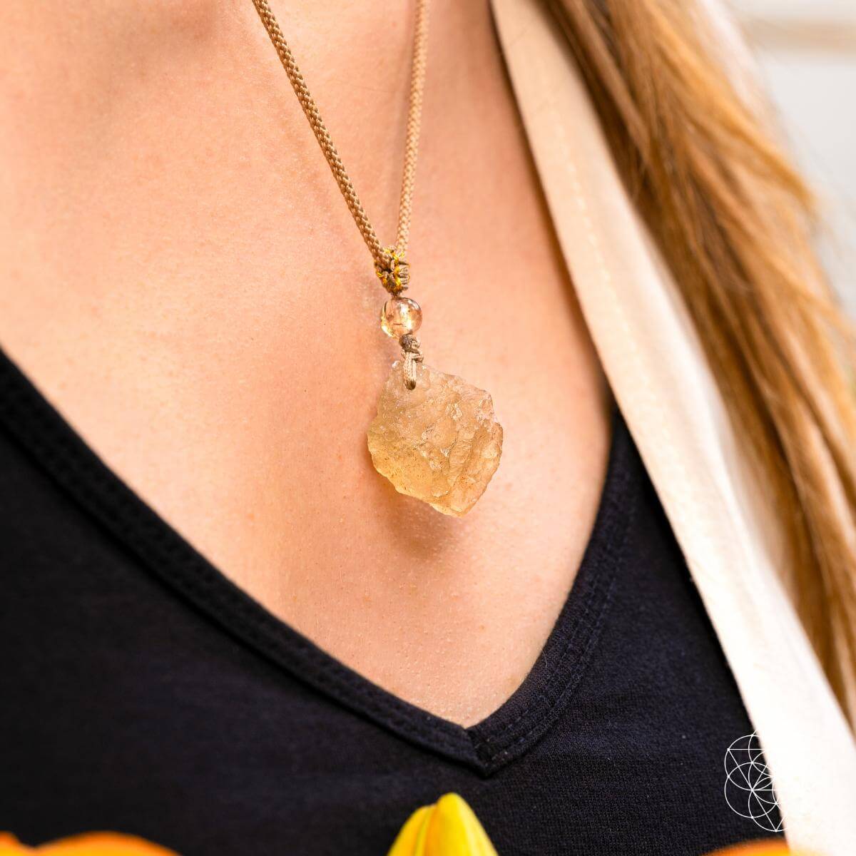 Necklace with a yellow pendant worn by a person