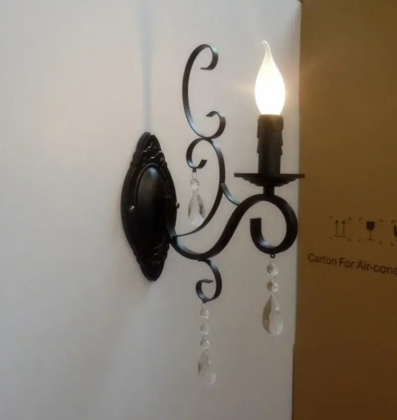 Decorative wall sconce with a light bulb on a white wall.